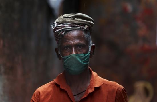 12月14日，在印度孟买，一名男子戴口罩出行。新华社 图